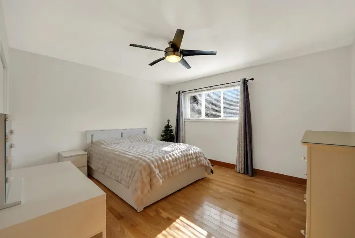 Bedroom with light wood-style floors and a ceiling fan
