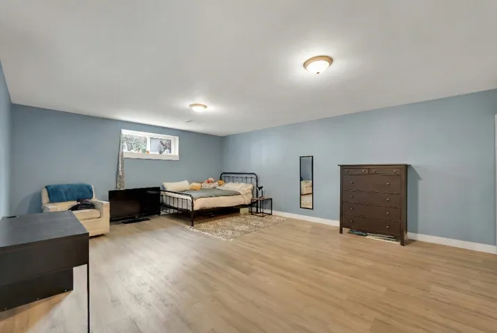 Bedroom with light wood-type flooring and baseboards