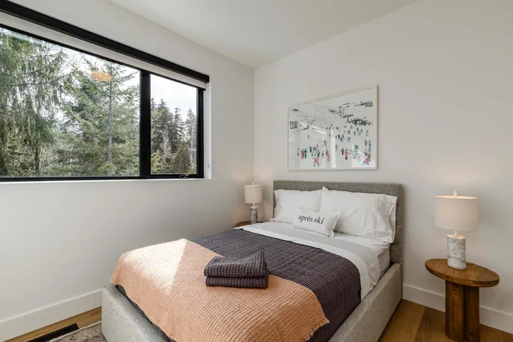 Bedroom featuring black out blinds, wood-like finished floors and natural light