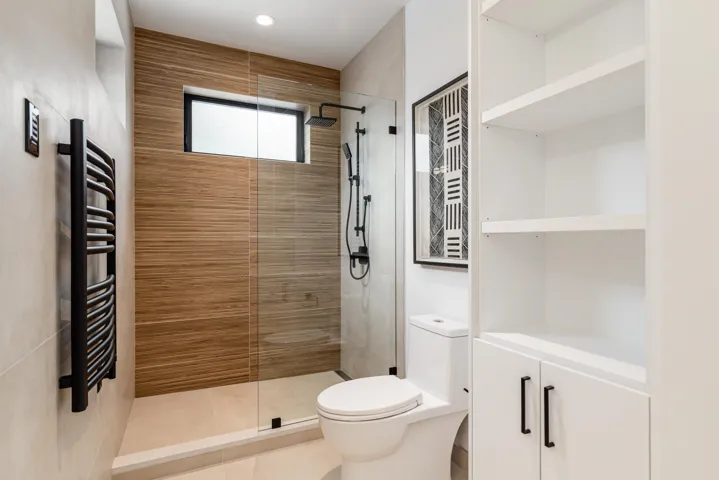 Bathroom featuring vanity, heated flooring, heated towel rack and tiled shower