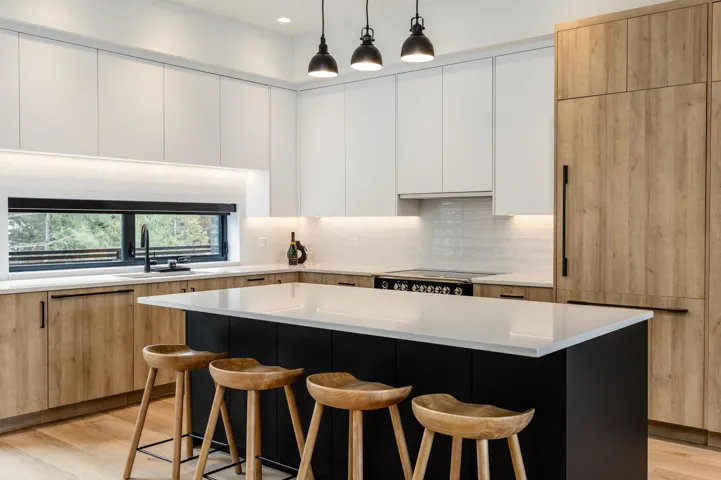 Kitchen featuring a kitchen breakfast bar, backsplash, modern cabinets, and light wood-style flooring