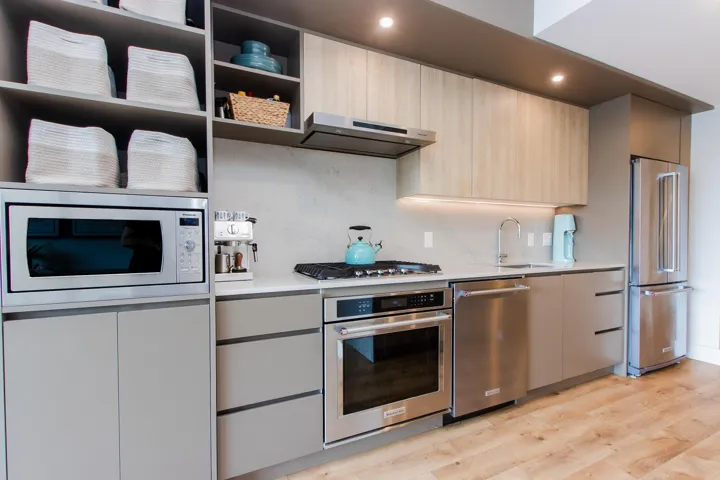Kitchen with stainless steel appliances, modern cabinets, open shelves, and light wood-style flooring