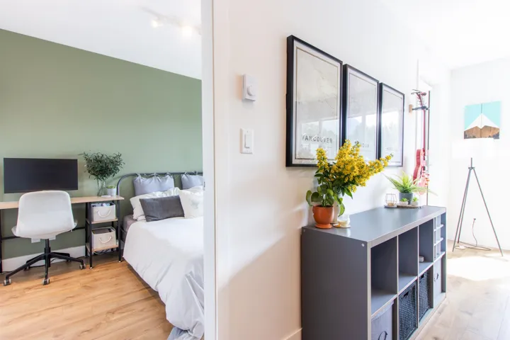 Bedroom with light wood finished floors and a desk