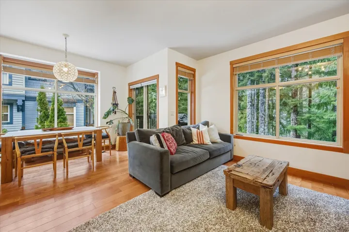 Living room featuring light wood-type flooring, healthy amount of natural light, and suspended lighting