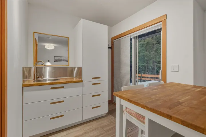 Kitchen featuring white cabinets, wood counters, light wood-style floors, and modern cabinets