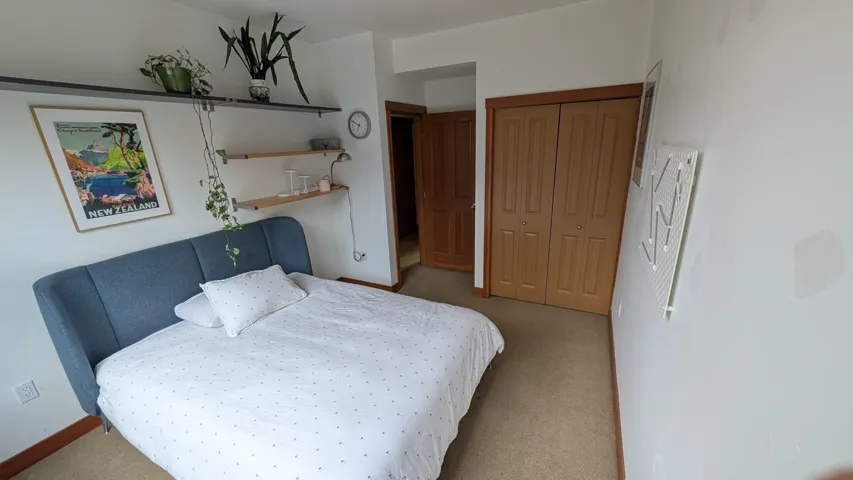 Carpeted room featuring light wood bifold closet doors and white painted walls