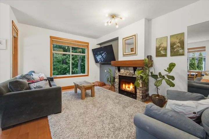 Living area with wood finished floors and a stone fireplace