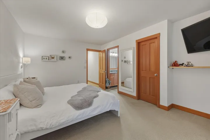 Bedroom with light colored carpet and ensuite bathroom