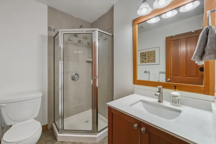 Full bath featuring vanity and a shower stall