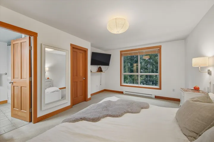 Bedroom featuring a baseboard radiator and light carpet