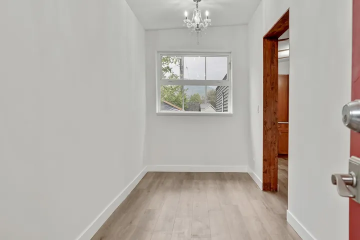 Hallway featuring light wood-type flooring and a chandelier