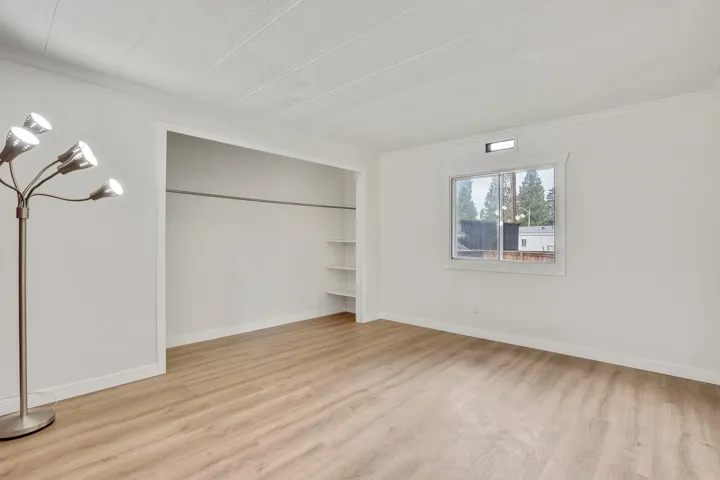 Unfurnished bedroom featuring light wood-type flooring, ornamental molding, and a closet