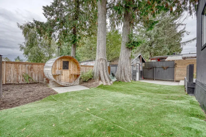 Fenced backyard featuring a storage shed