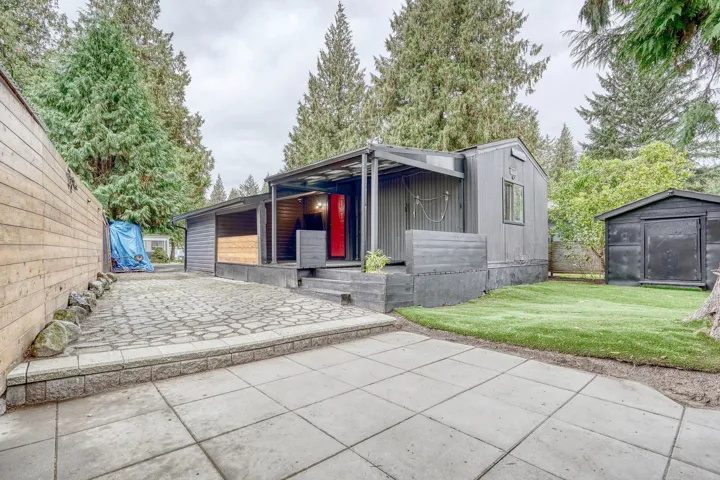 View of front of property with a shed, a patio, and board and batten siding