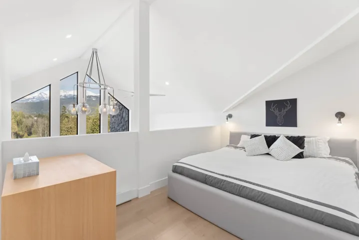 Bedroom with baseboards, wood finished floors, and lofted ceiling