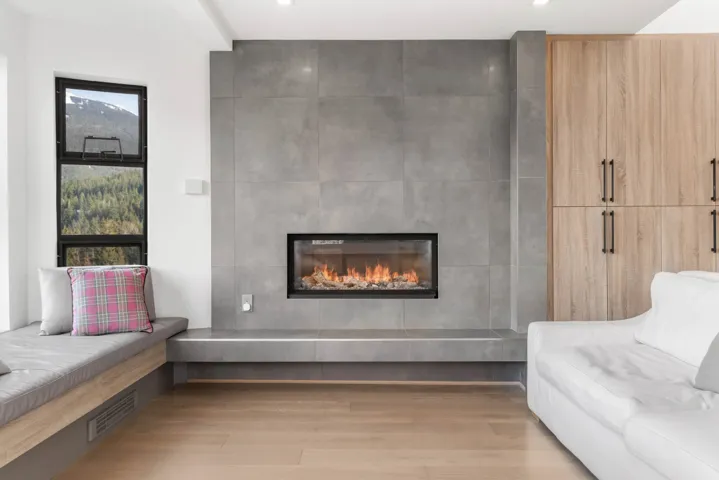 Sitting room featuring a tiled fireplace, visible vents, and wood finished floors