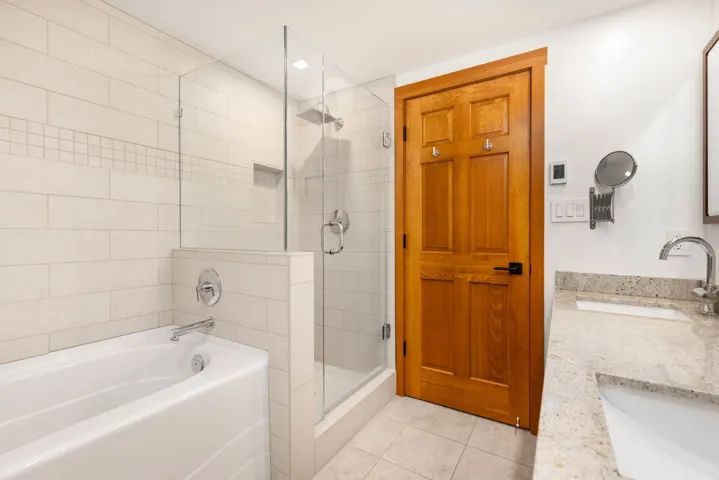 Bathroom with a shower stall, tile patterned floors, a garden tub, and vanity