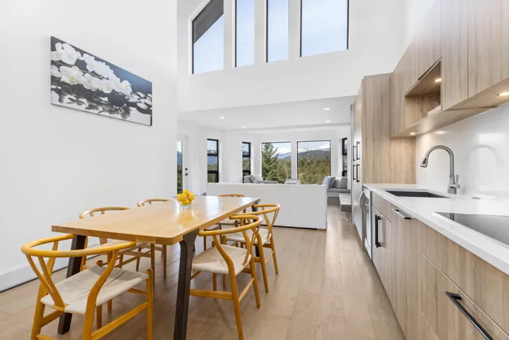 Dining space with a towering ceiling and light wood-style floors