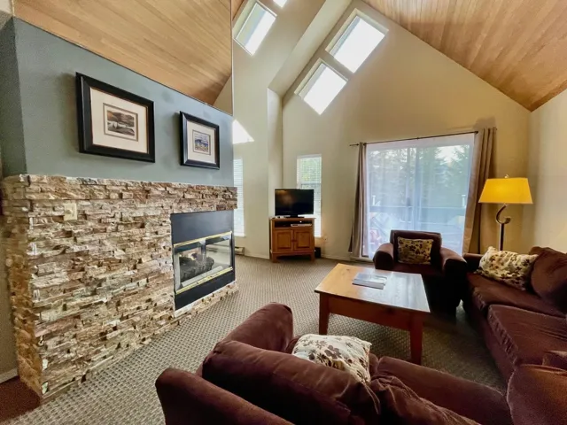 Living area featuring carpet floors, lofted ceiling, wood ceiling, and a fireplace