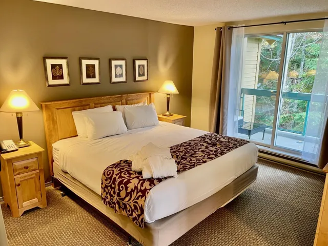 Bedroom featuring carpet, access to exterior, and a textured ceiling