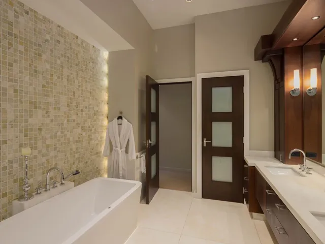Full bathroom featuring a freestanding bath, double vanity, tile walls, light tile patterned flooring, and recessed lighting