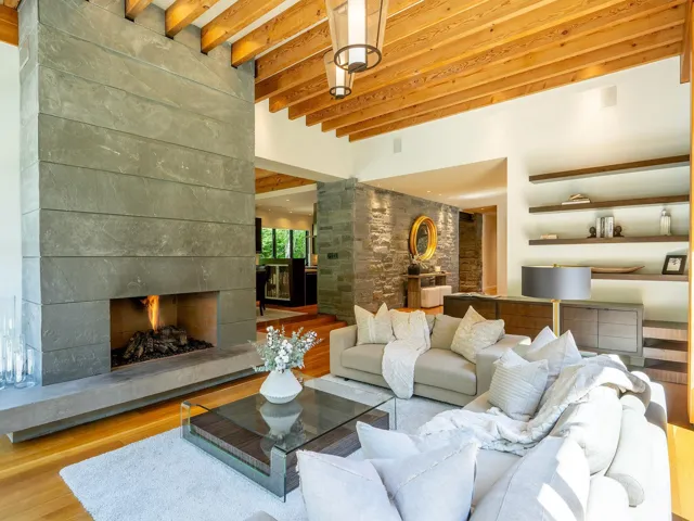 Living area with beam ceiling, a tiled fireplace, and wood finished floors