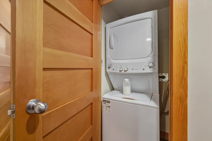 Laundry area with stacked washer and clothes dryer