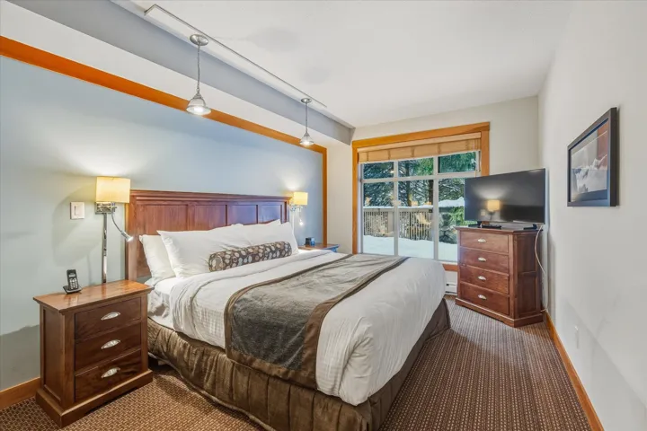 Carpeted bedroom with baseboards and access to outside
