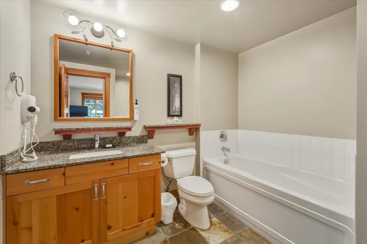 Full bathroom with vanity, a bath, and recessed lighting