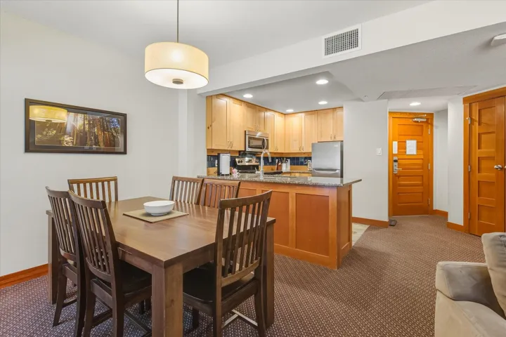 Dining room with recessed lighting and light colored carpet