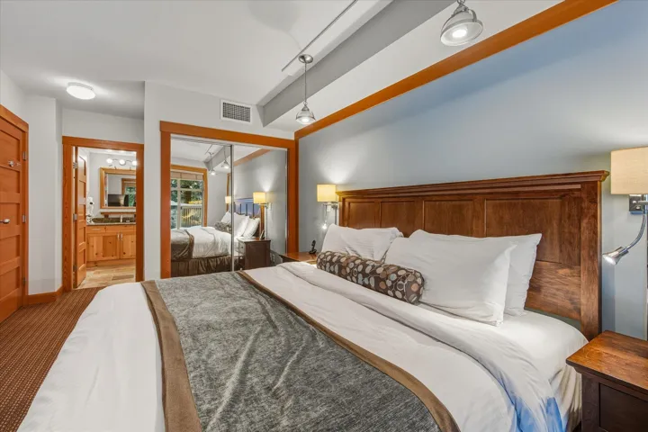 Carpeted bedroom featuring a closet and ensuite bath