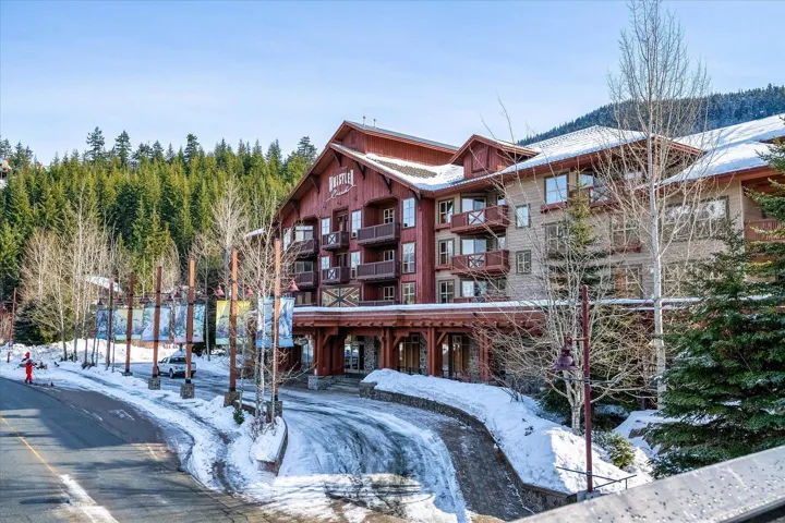 Snow covered building featuring a view of apartment building / complex