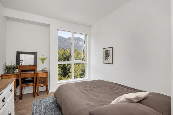Bedroom featuring a mountain view, light wood finished floors, and an office area