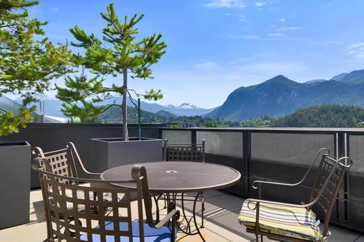 Wooden deck with a mountain view, outdoor dining space, and a patio area