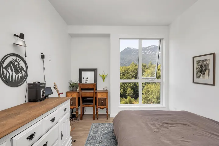 Bedroom featuring a desk, light wood-type flooring, and a mountain view