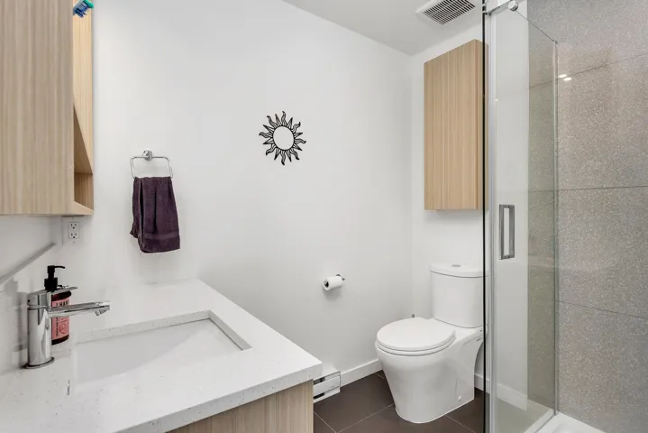 Bathroom with vanity, dark tile patterned floors, a stall shower, and a baseboard radiator