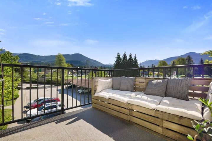 Outdoor patio featuring a black metal railing and a mountain backdrop