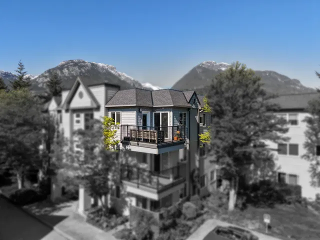 Balcony access featuring a black metal railing, concrete flooring, and a broad mountain backdrop
