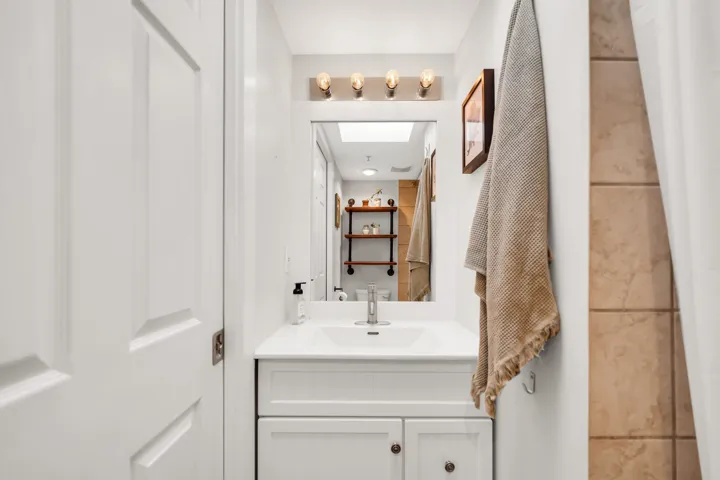 Bathroom vanity featuring a single basin, white countertop, and under-sink cabinetry