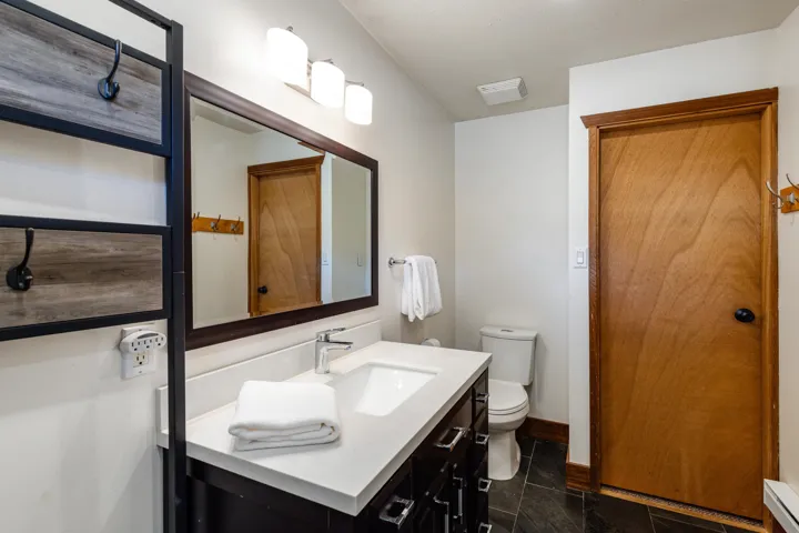 Bathroom with toilet, vanity, baseboards, and baseboard heating