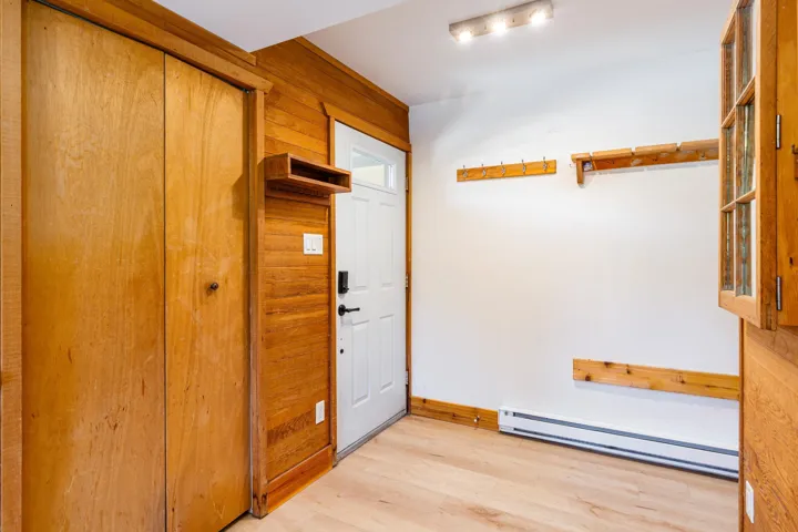 Entrance foyer with a baseboard heating unit and light wood-style flooring