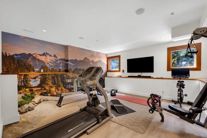 Recreation room featuring an expansive landscape mural wall, light wood-finish flooring, recessed lighting, and two windows with wood trim