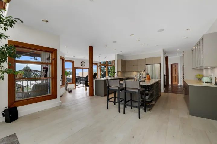 Spacious kitchen featuring two-tone cabinetry, stainless steel appliances, and a central island with seating