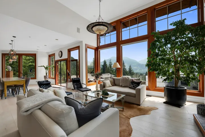 Expansive living area featuring soaring ceilings and large-format wood-framed windows