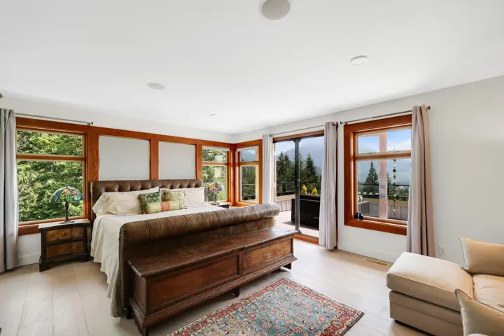 Bright room featuring extensive natural wood-framed windows, light wood-finish flooring, and recessed ceiling lighting