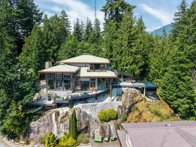 Multi-level residence featuring a metal roof and extensive glass windows