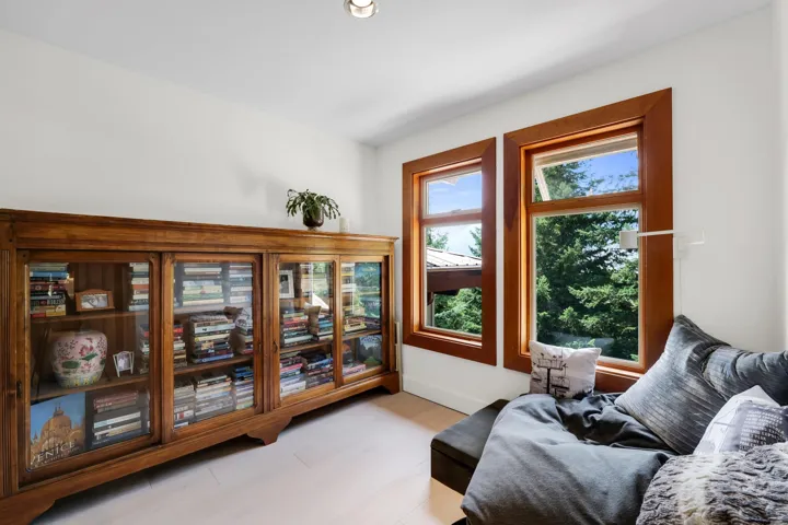 Recessed ceiling lighting illuminates a room with light wood-finish flooring and white walls