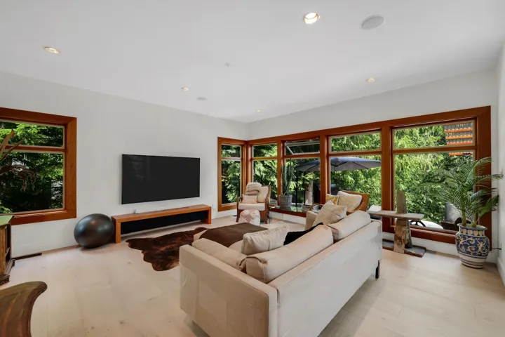 Spacious living area featuring light wood-finish flooring and recessed ceiling lights