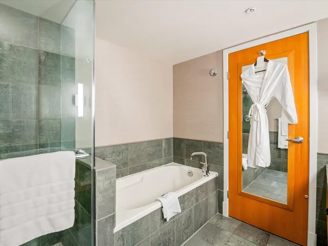 Carpeted living room with a textured ceiling, visible vents, baseboards, ornamental molding, and a glass covered fireplace