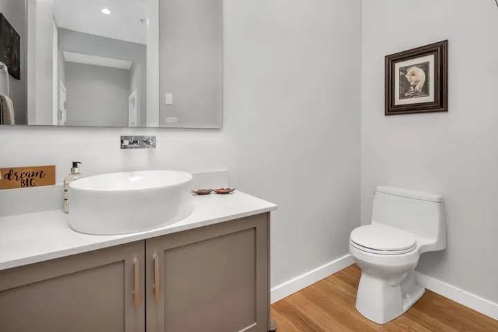 Half bathroom with wood finished floors and vanity